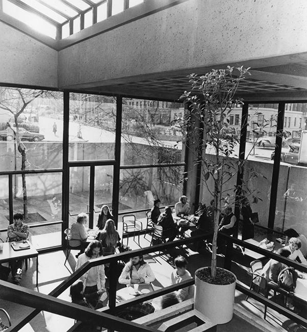 20世纪70年代的现代房间，有餐桌，里面坐满了学生